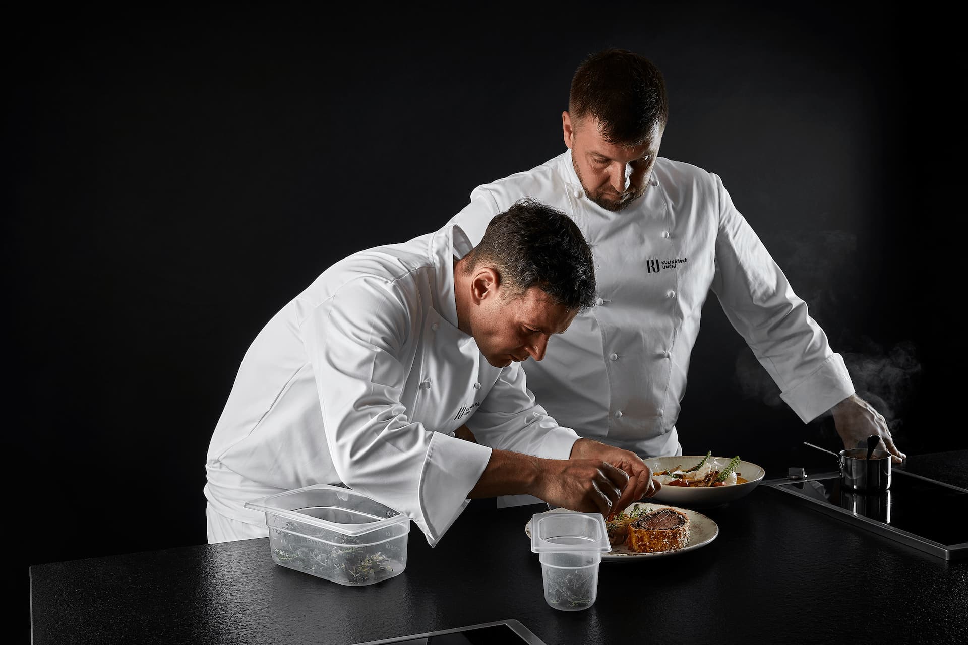 Dva kuchaři připravují pokrm